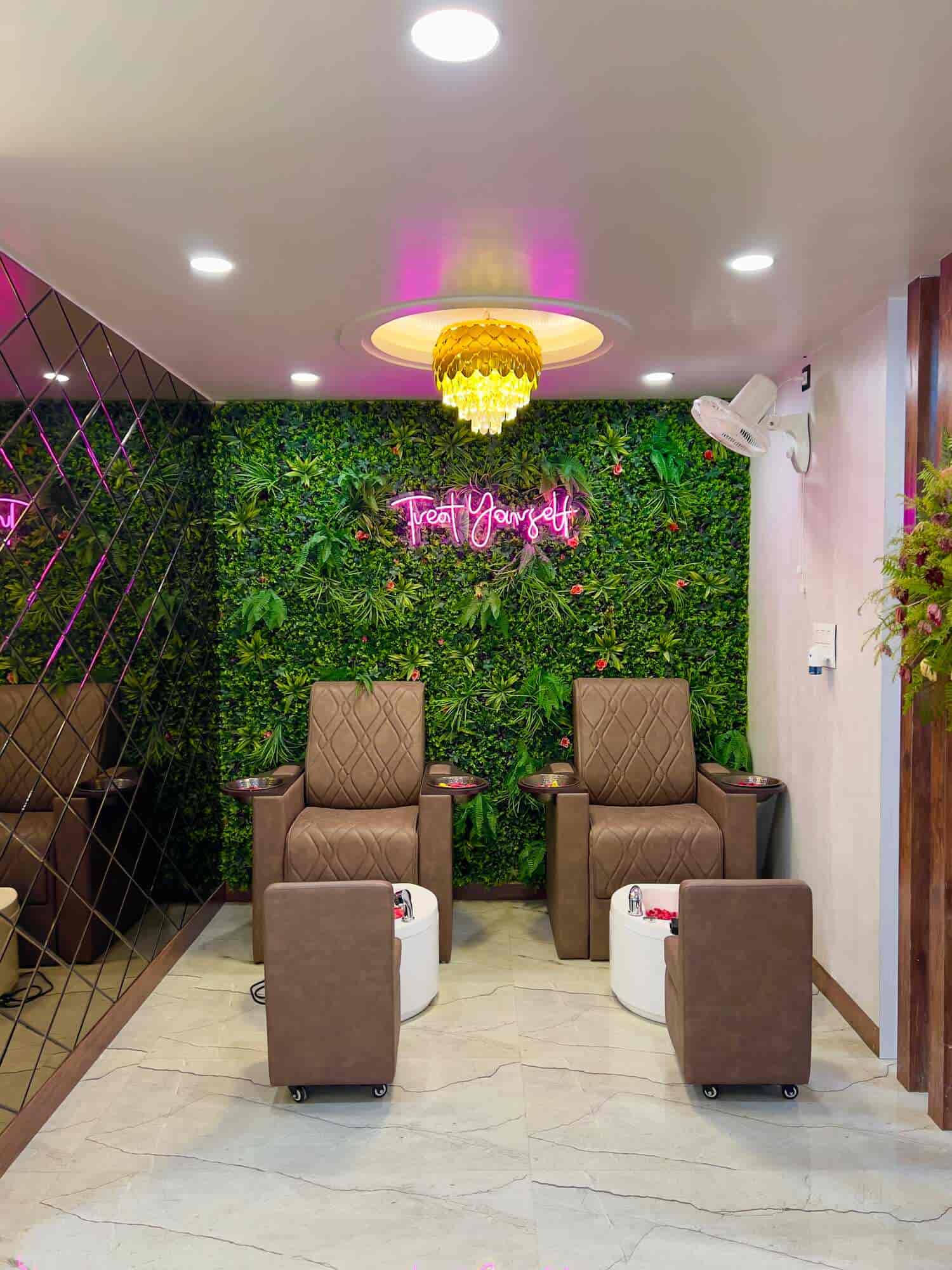 Spa pedicure area — living green wall, Treat Yourself neon, gold chandelier